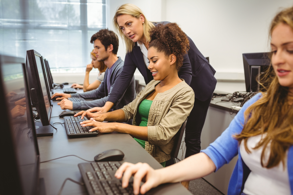 Teacher helping her student in computer class at the university