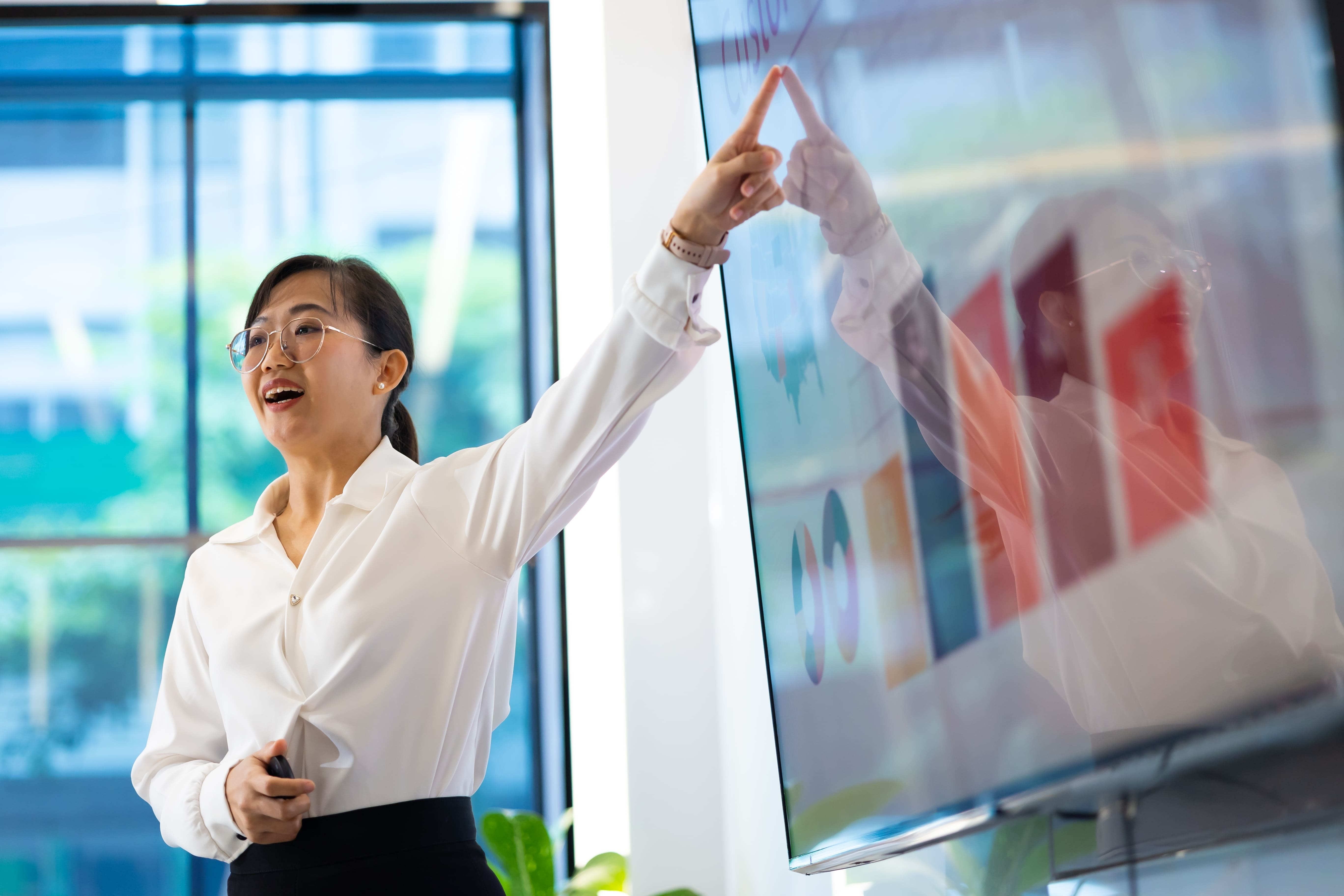 Women pointing to and presenting data in business meeting