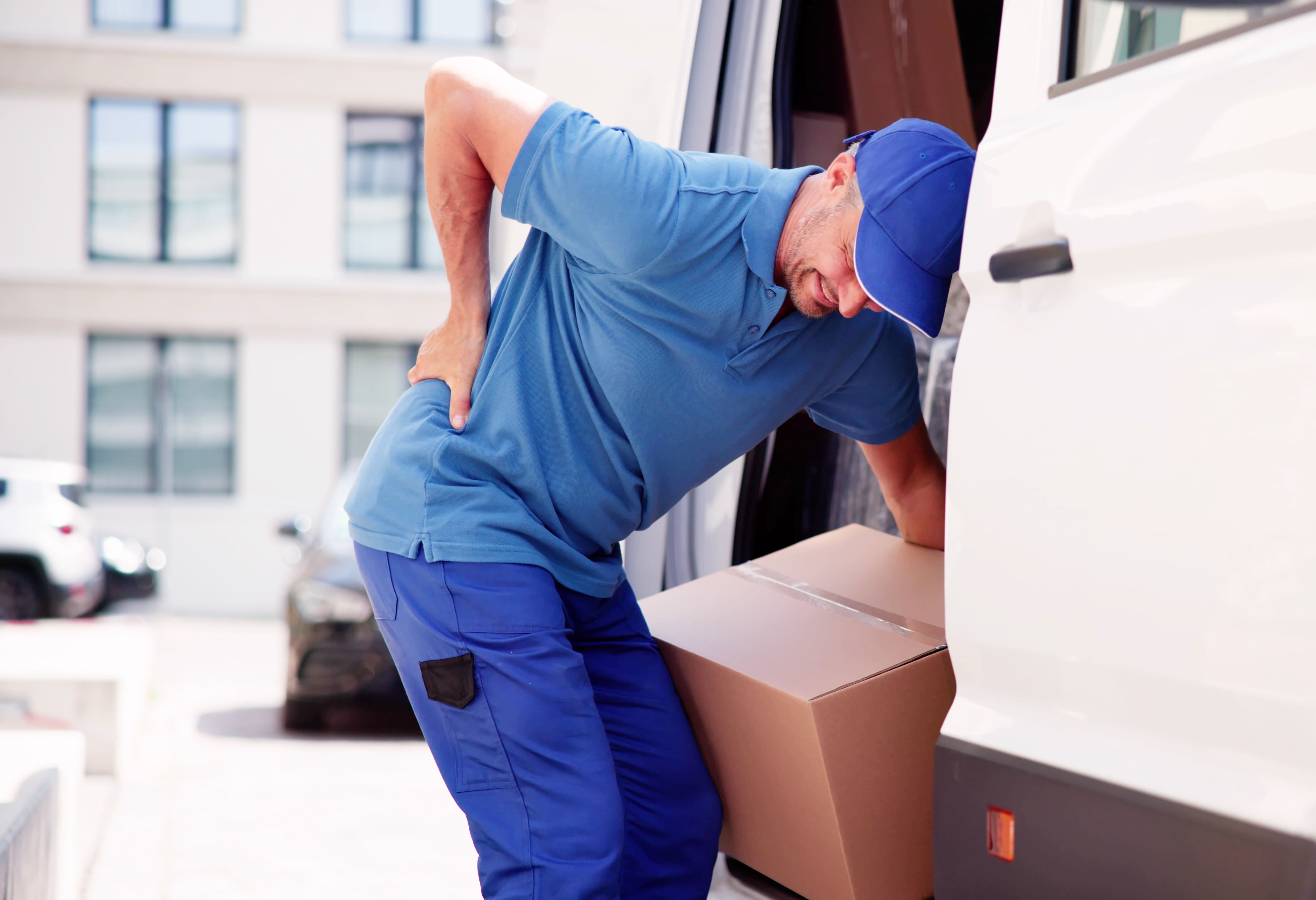 Man lifting box with poor ergonomics